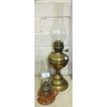A brass oil lamp with glass chimney, 57cm high overall and a smaller glass oil lamp with handle, (