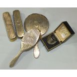 A silver-backed engine-turned hand mirror, two clothes brushes and a hairbrush marked 'Mary', London