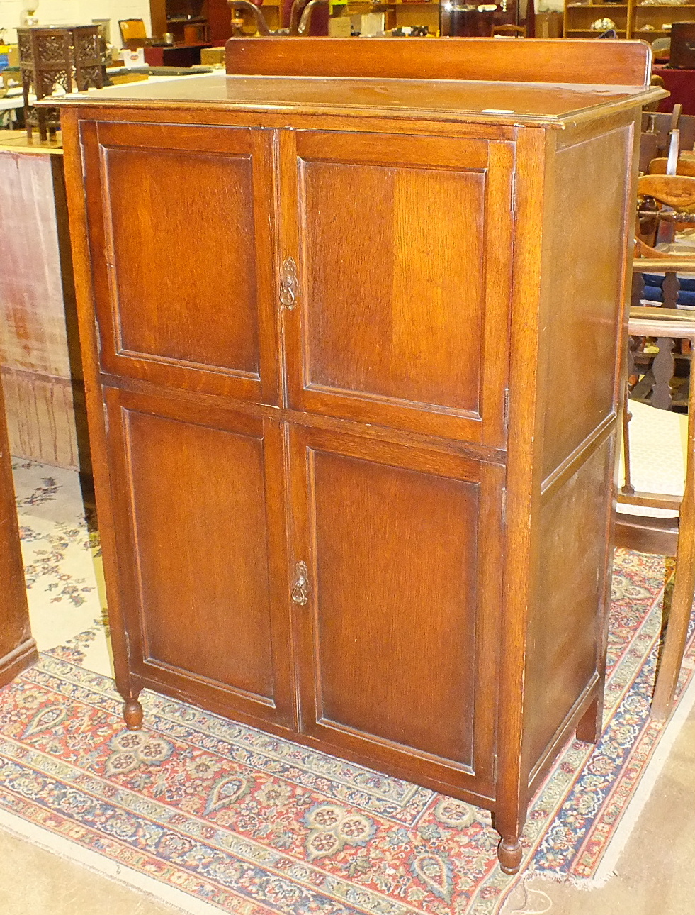 A mid-20th century oak tallboy, having four panelled doors, 90cm wide.