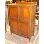 A mid-20th century oak tallboy, having four panelled doors, 90cm wide.