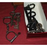 A collection of large vintage keys and a pair of handcuffs.