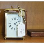 A brass-cased carriage clock with carrying handle, the enamel dial marked 'Winsor, Bishop & Co,