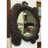 An oval bevelled mirror plate within a hardwood frame carved with a Peacock and engraved 'A Fair