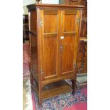 An early 20th century mahogany music cabinet, having a pair of panel doors enclosing ten shelves,