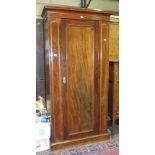 A late-19th/early-20th century mahogany wardrobe, the cornice above a single door, on plinth base,