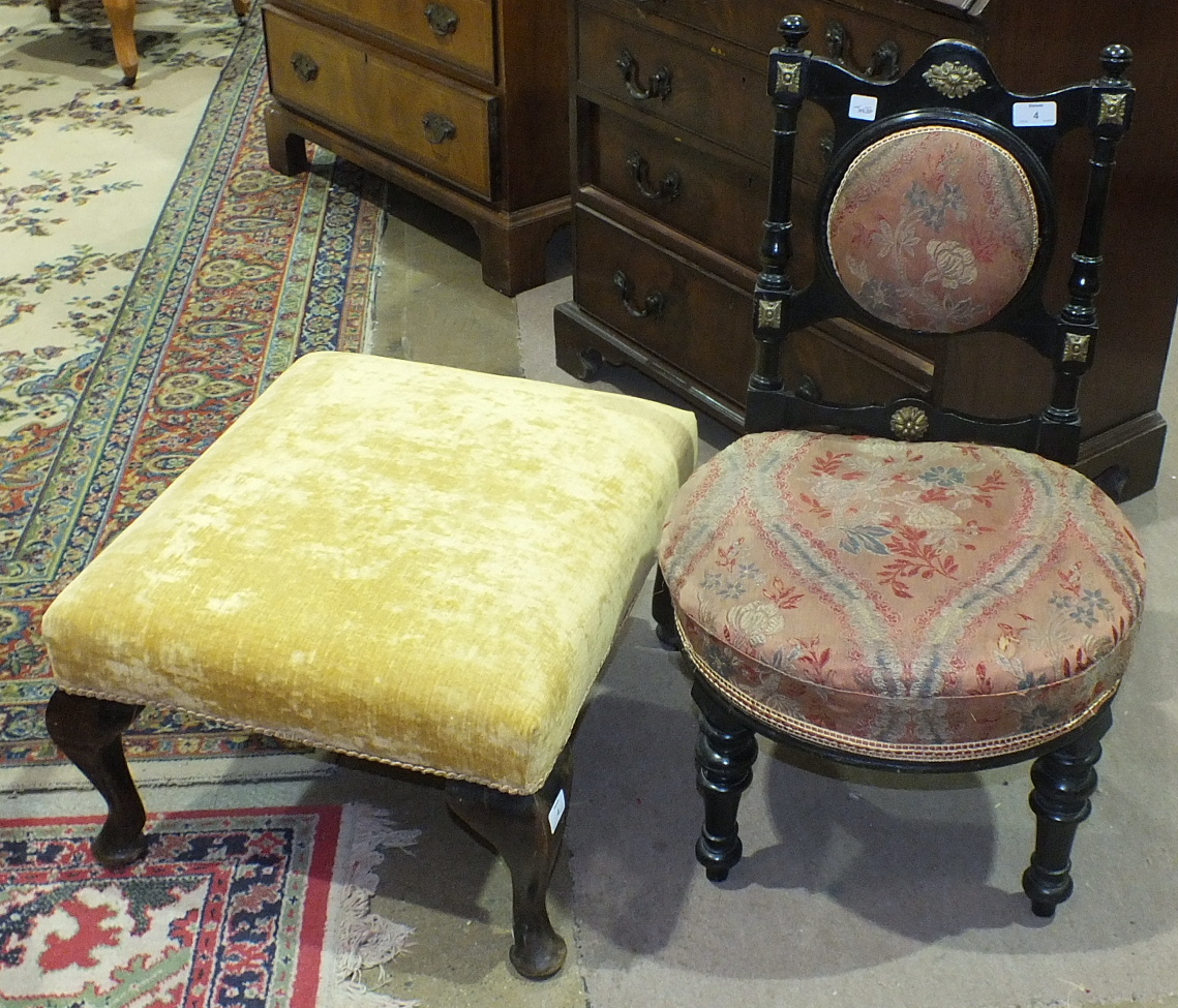 An ebonised late-Victorian nursing chair with padded back and upholstered seat, on turned front legs