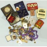 A metal George VI souvenir Six Oxo Cubes money box, an 8-day travelling clock, various badges and