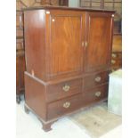 An early-19th century mahogany small linen press having a pair of panelled doors enclosing five