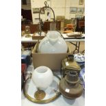 A brass hanging oil lamp with white glass shade, two other oil lamps, various boxed games and