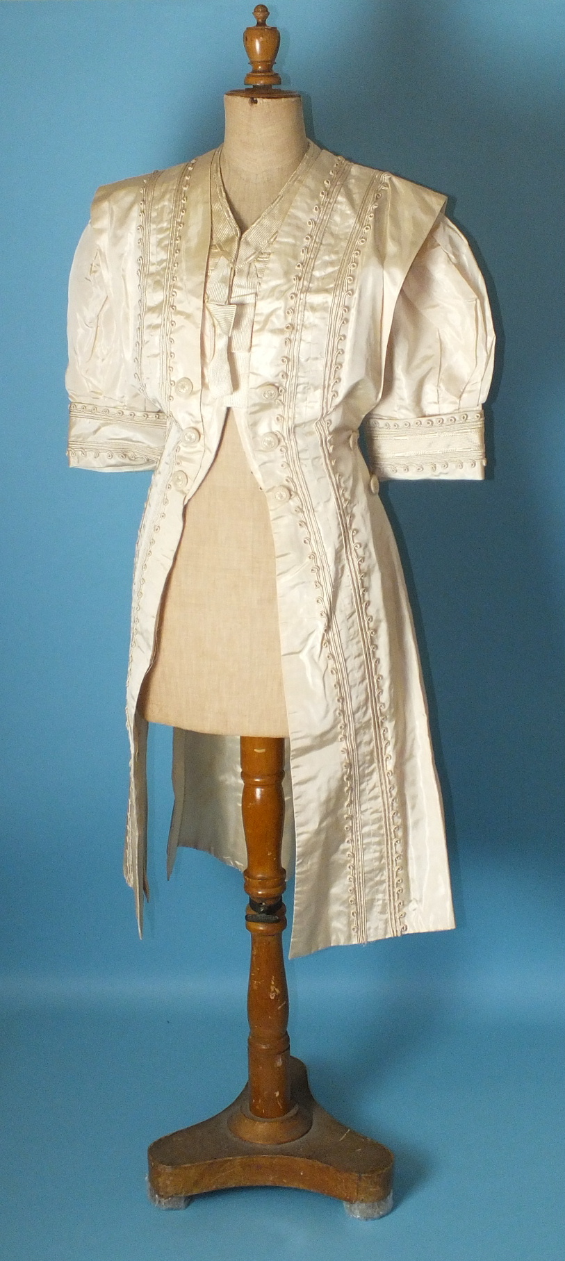 A late-19th century French cream silk coat with puff sleeves, decorated overall with silk braid