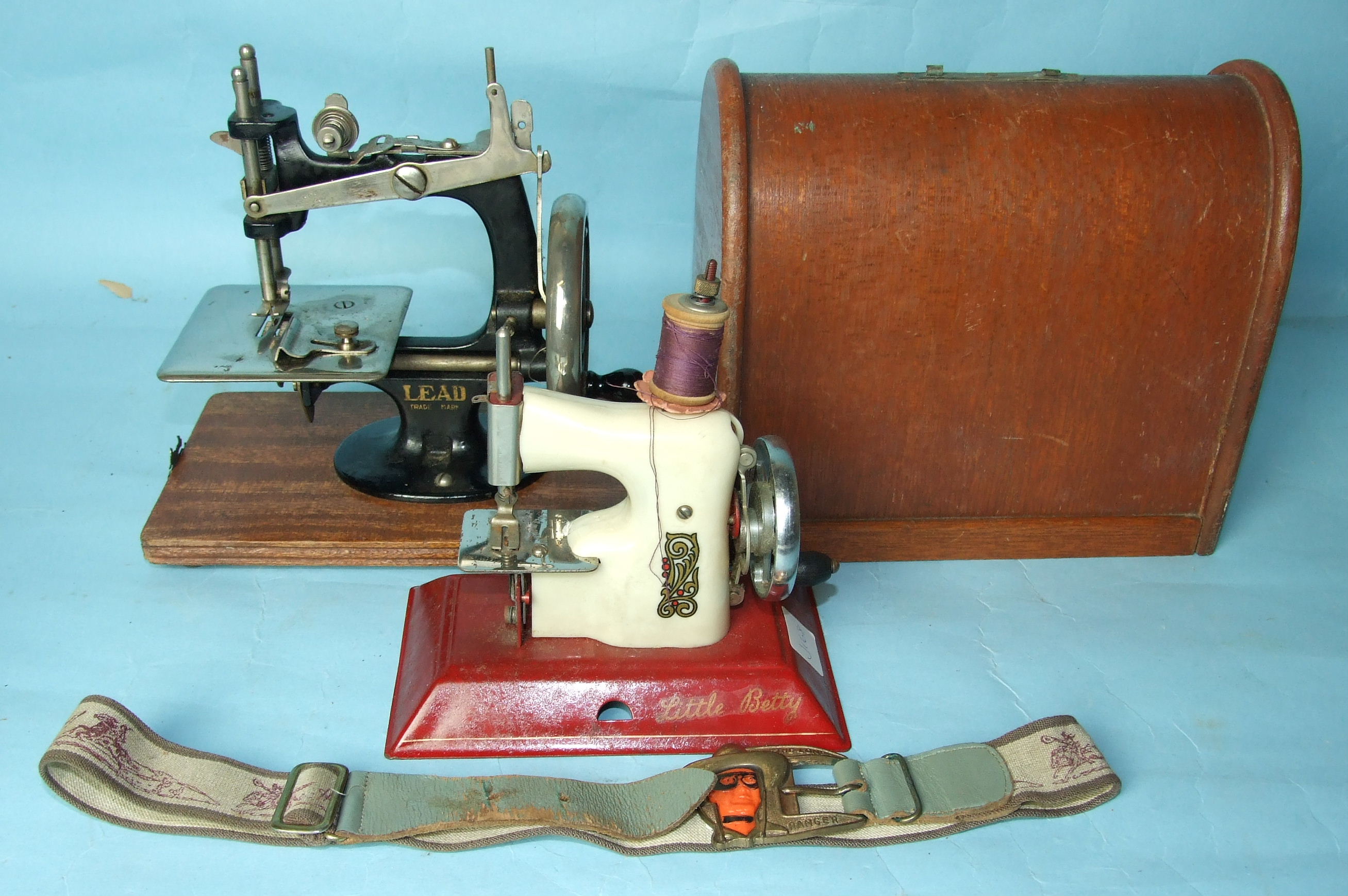 A cased miniature sewing machine by 'LEAD', (handle and catches of case missing), a later "Little