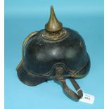 A vintage Great War era pickelhaube, black leather skull with cuprous spike, lacking badge insignia,