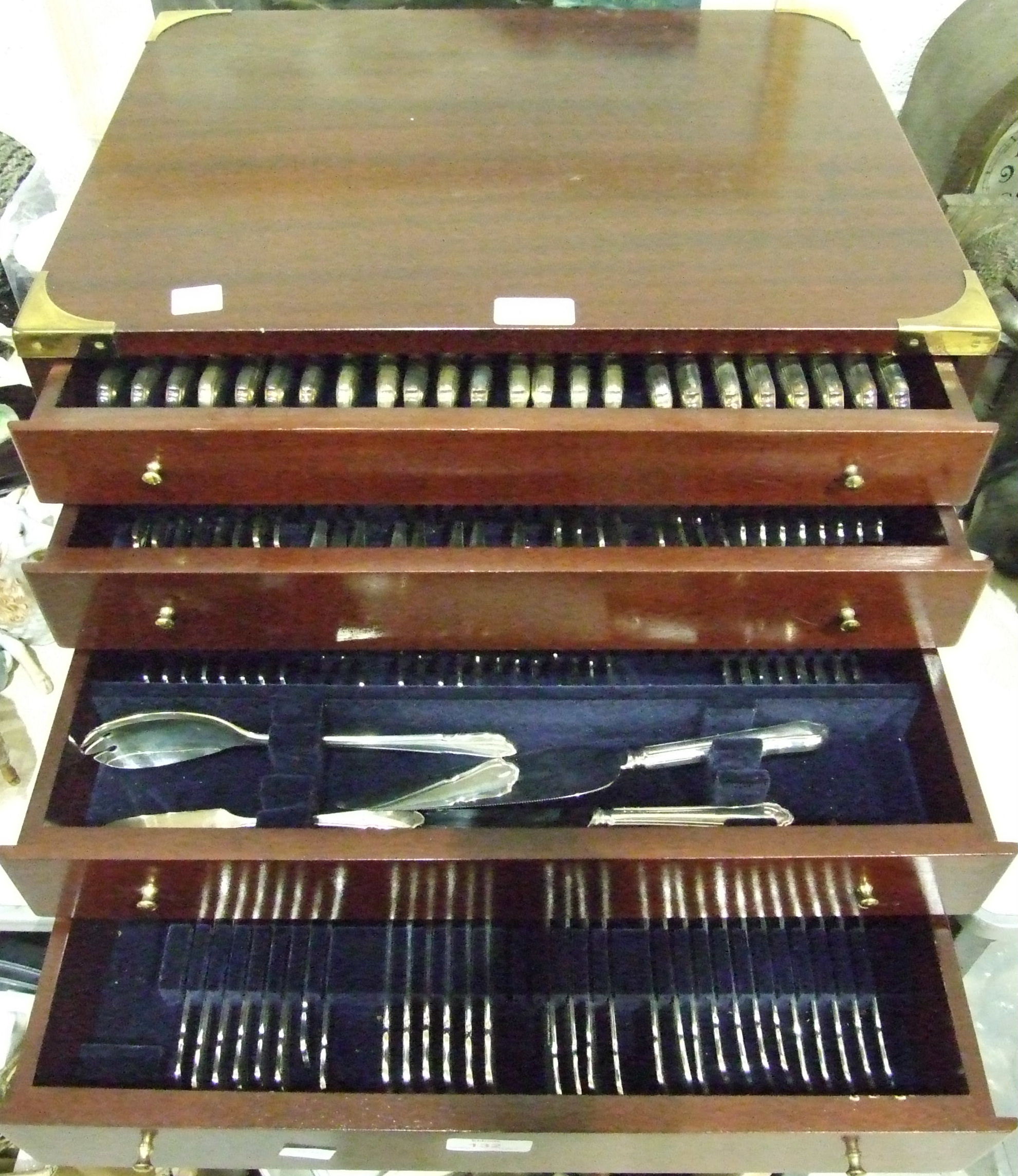 A part canteen of modern cutlery contained in a mahogany finished four-drawer chest.