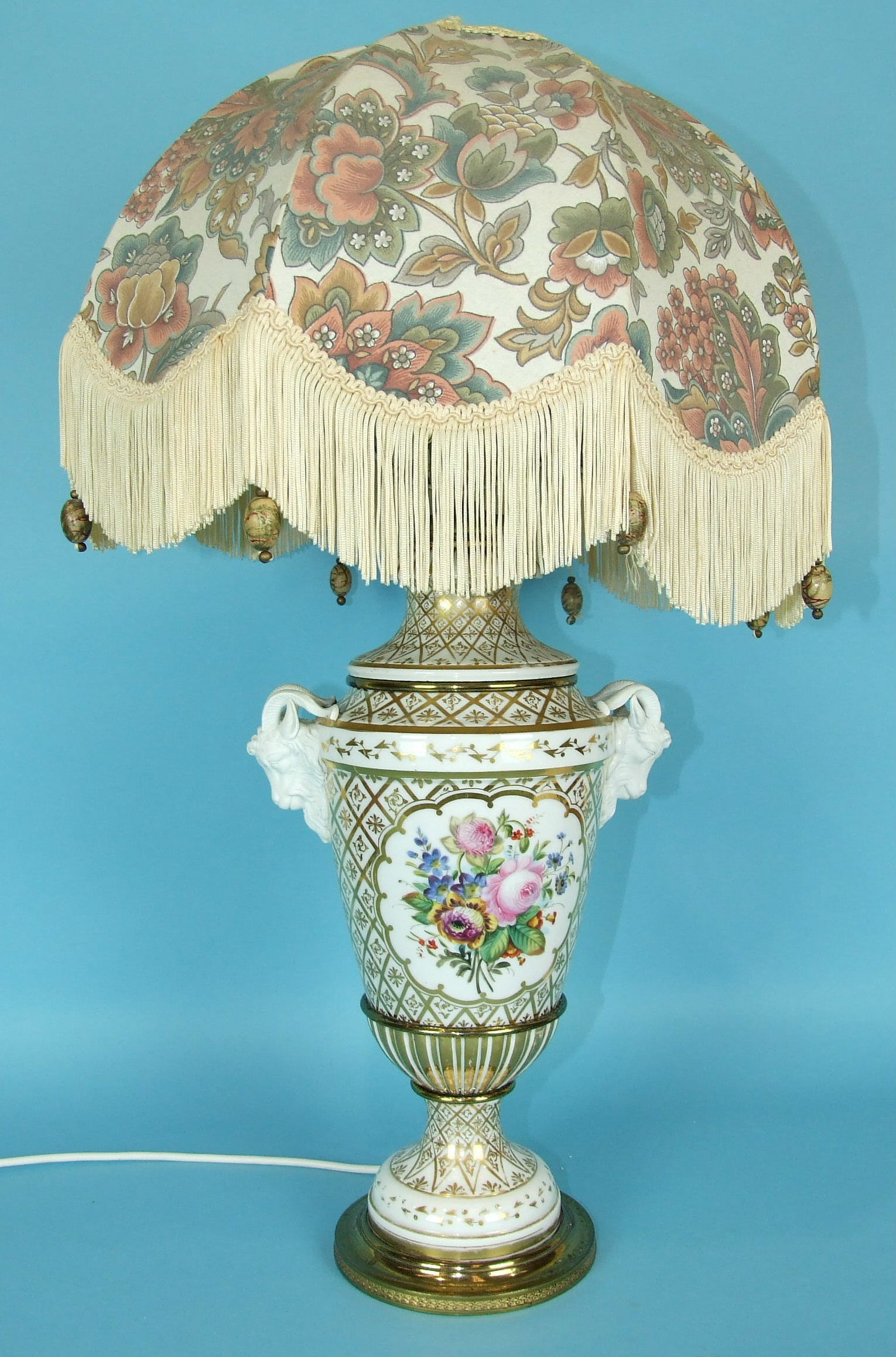 A large 19th century French porcelain vase decorated with panels of flowers on a white and gilt