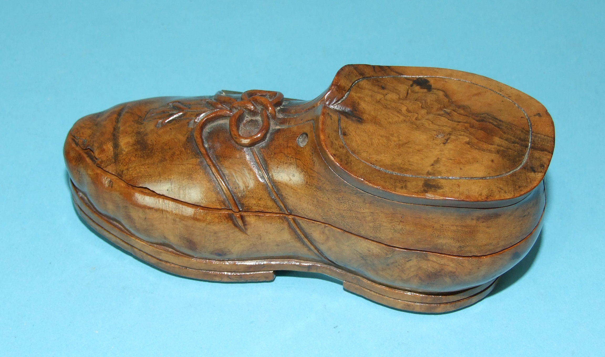 A carved root wood inkwell in the form of a boot, the hinged lid revealing a glass lined inkwell,