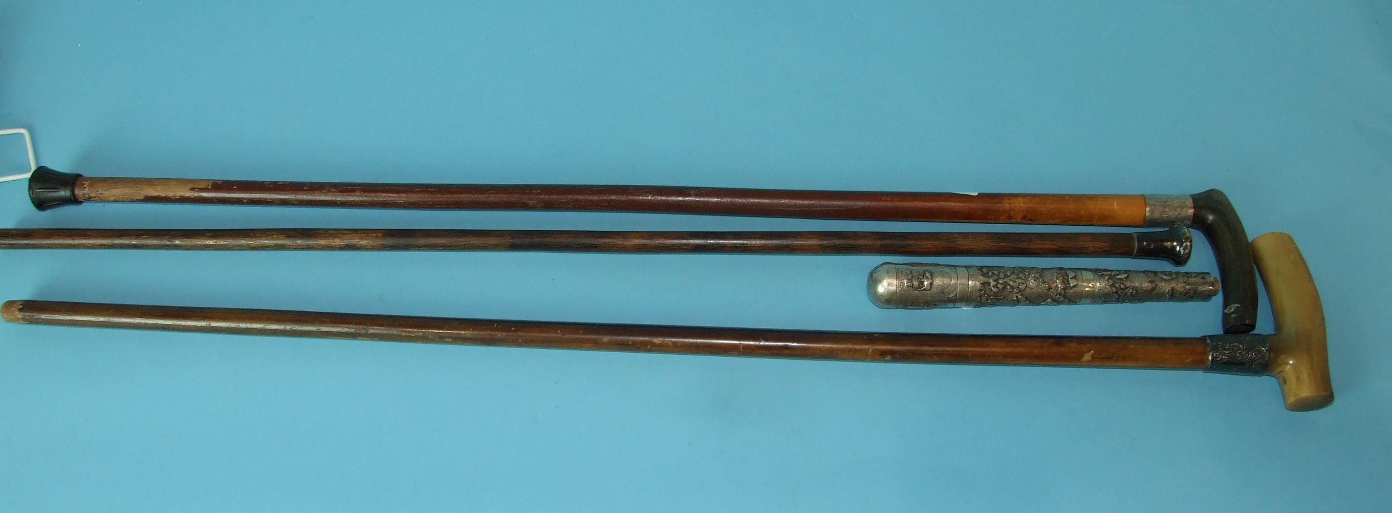 Three silver-mounted walking canes and a Burmese white metal parasol handle, (4). - Image 2 of 2