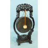 A Chinese carved hardwood gong stand with bronze circular gong and beater, gong 43cm diameter, 107cm