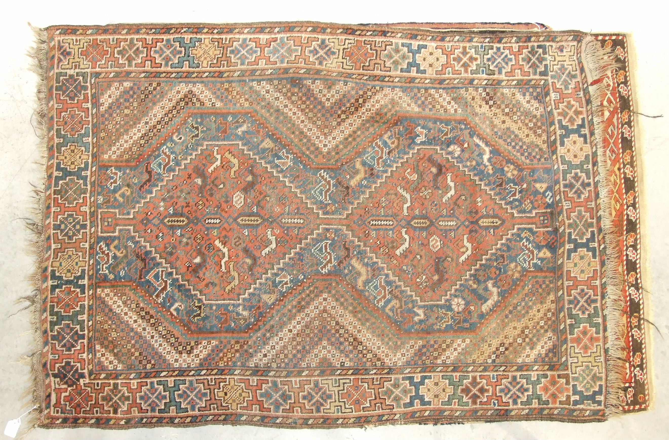 A mid-20th century wool rug, red field with central hexagonal medallions, figures leading camels and - Image 3 of 3