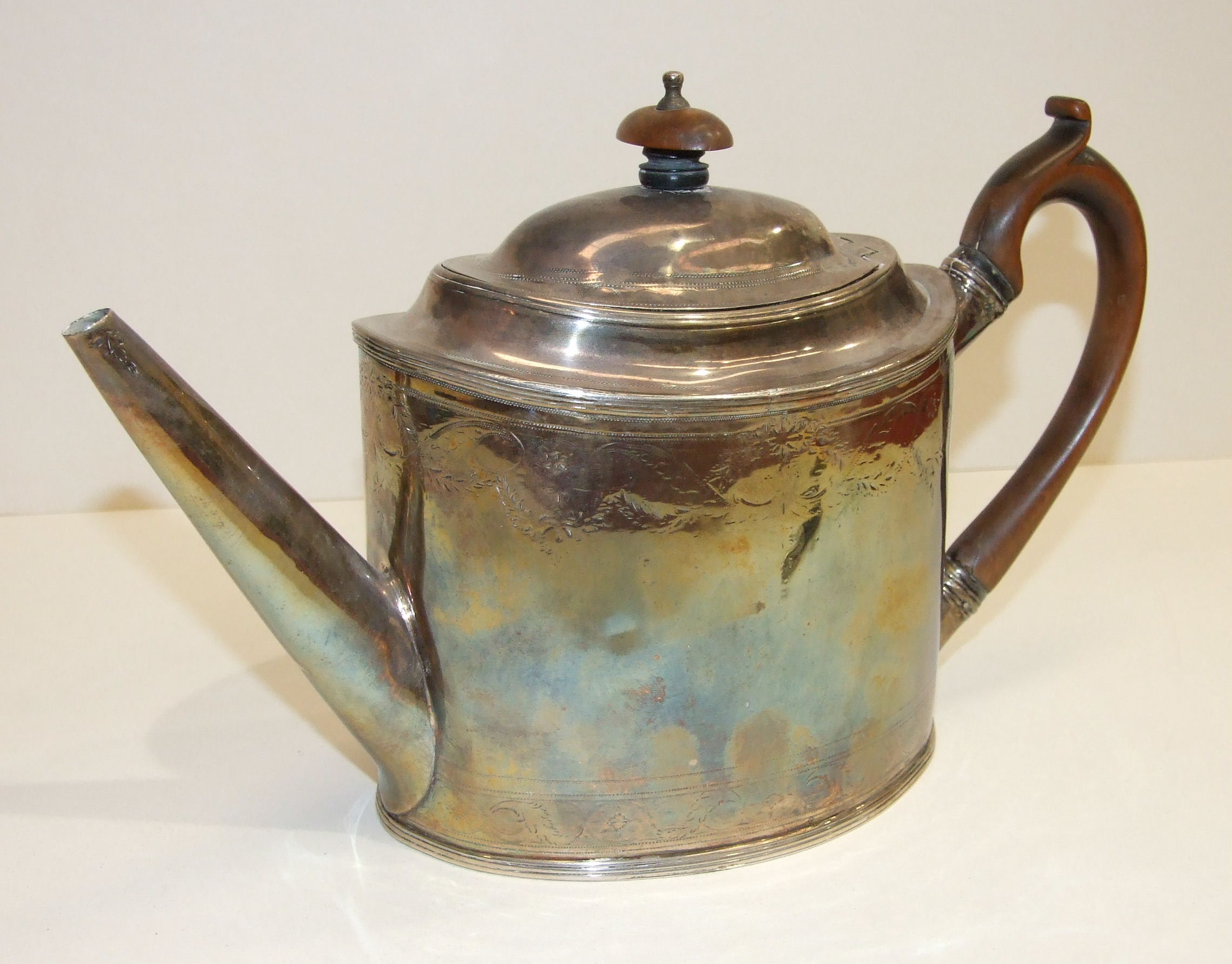 A George III oval teapot by Peter & Ann Bateman, of plain, slightly-tapered form, with wood finial