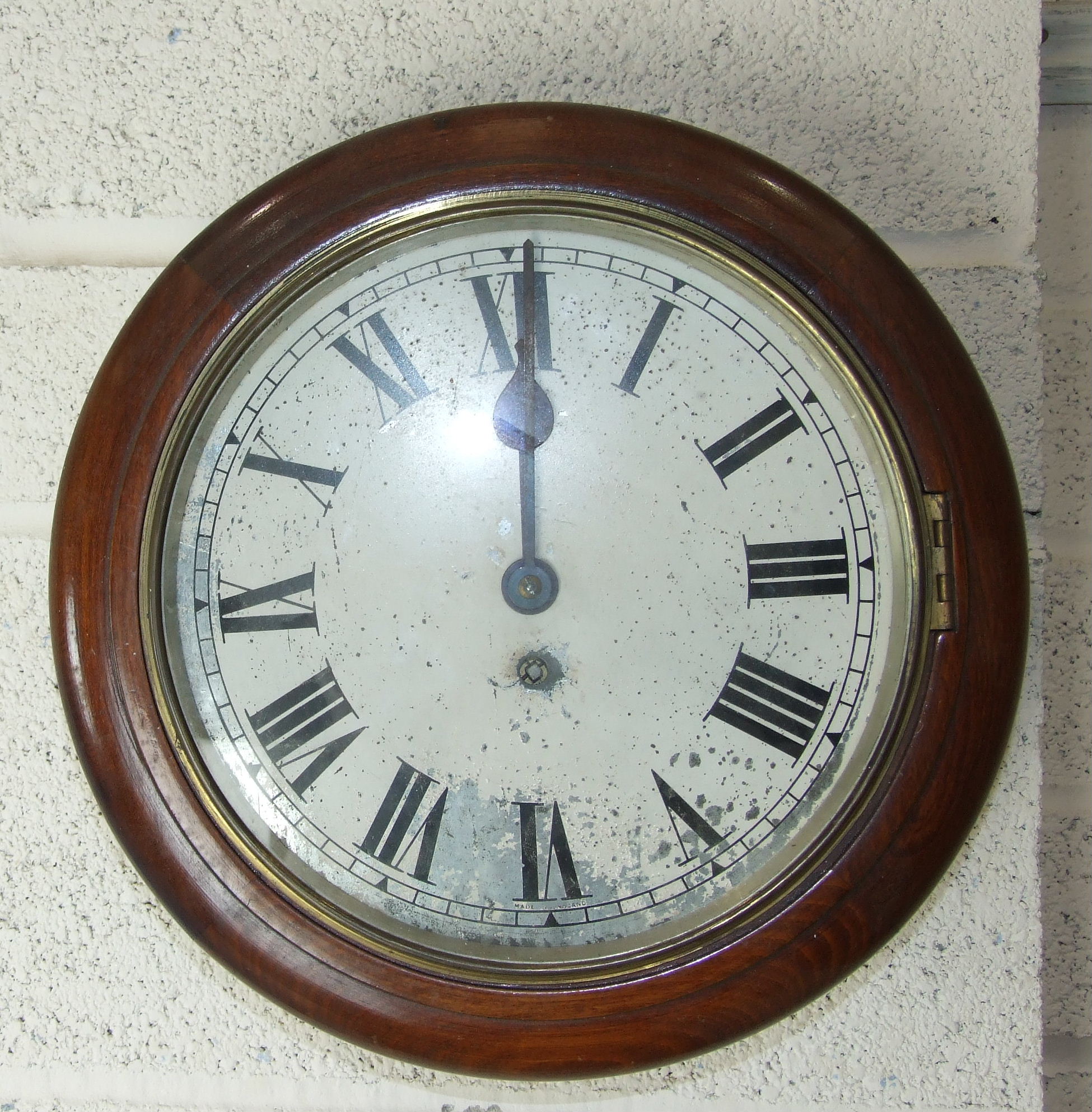 A Victorian stained wood circular wall clock, the worn enamelled dial with drum movement, 33cm