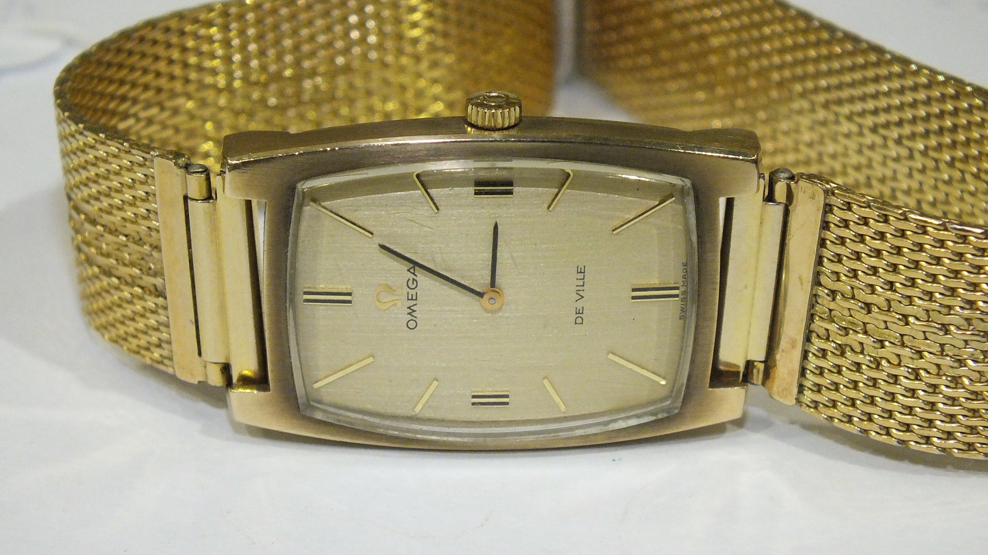 Omega de Ville, a gents wrist watch of rectangular cushion shape, the gilt face with baton numerals,