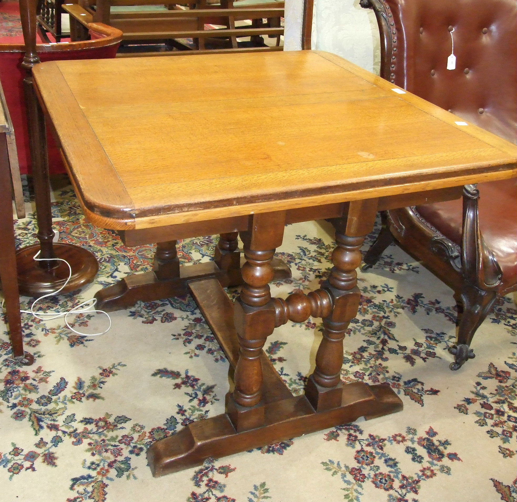 An oak draw leaf dining table on turned end-supports united by a stretcher, 150 x 1=90cm open, and