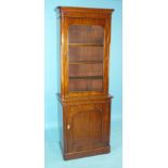 A Victorian mahogany narrow bookcase with single glazed door above a panelled door, 80cm wide, 213cm