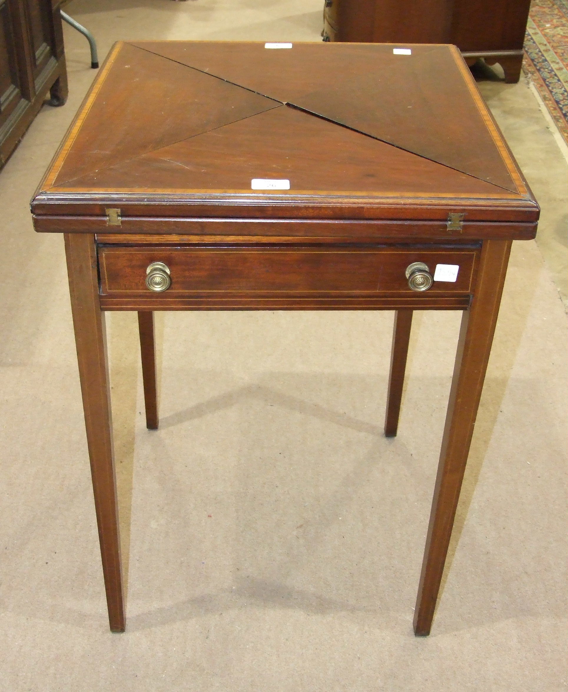 An Edwardian inlaid banded mahogany envelope card table fitted with single frieze drawer, on