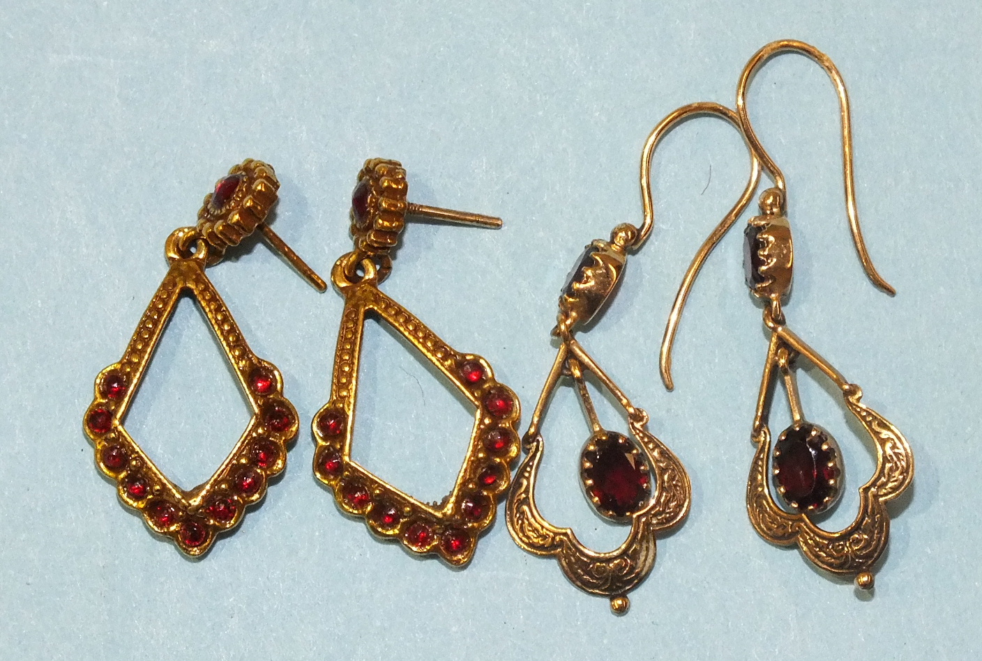 A pair of 9ct gold pendant earrings set garnets, marked "375", and a pair of plated earrings.