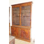 A reproduction mahogany Georgian bookcase, the dentil cornice above a pair of astragal-glazed