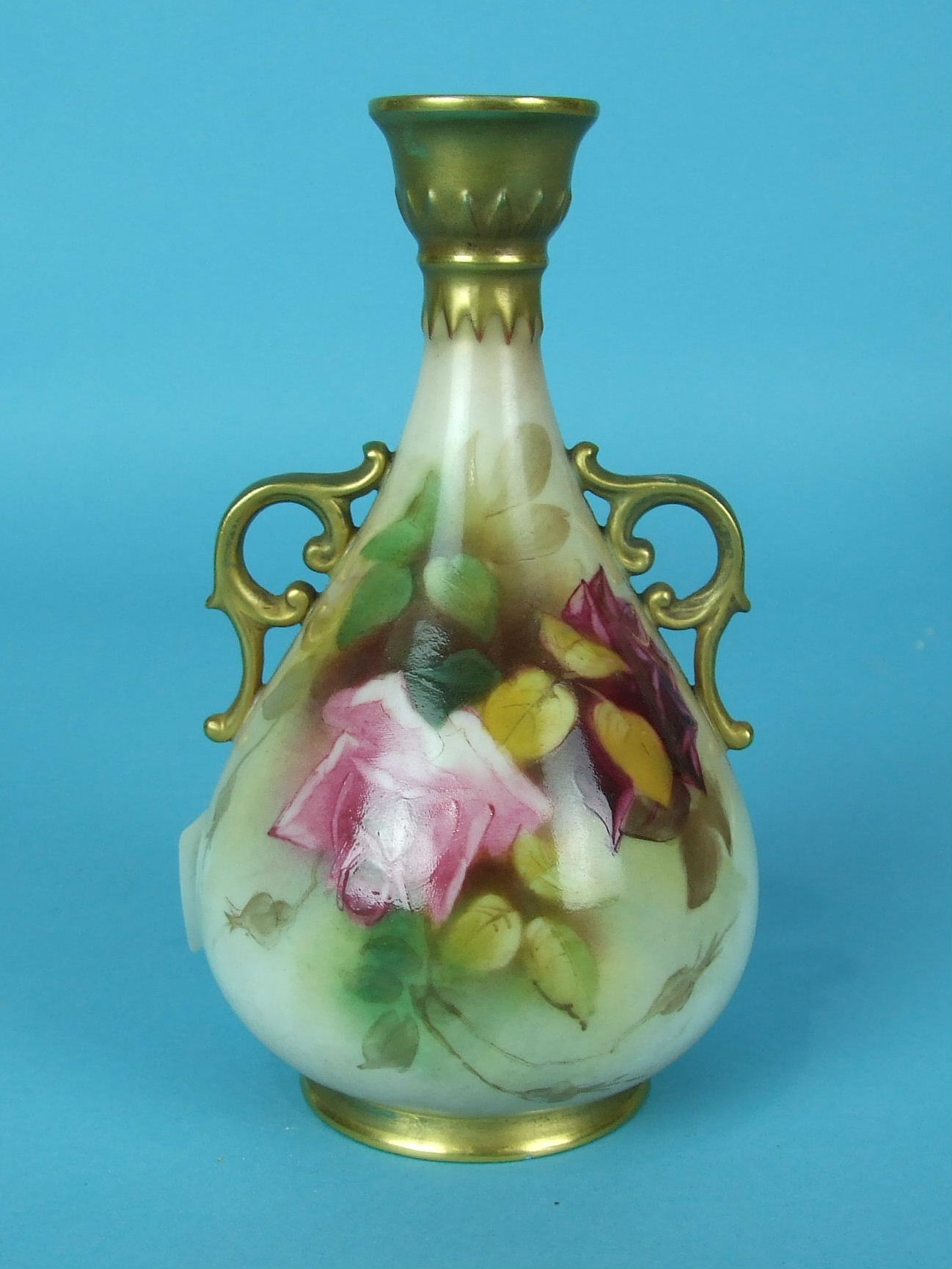 A Royal Worcester porcelain vase painted with roses and with gilt handles and rims, unsigned, 12cm