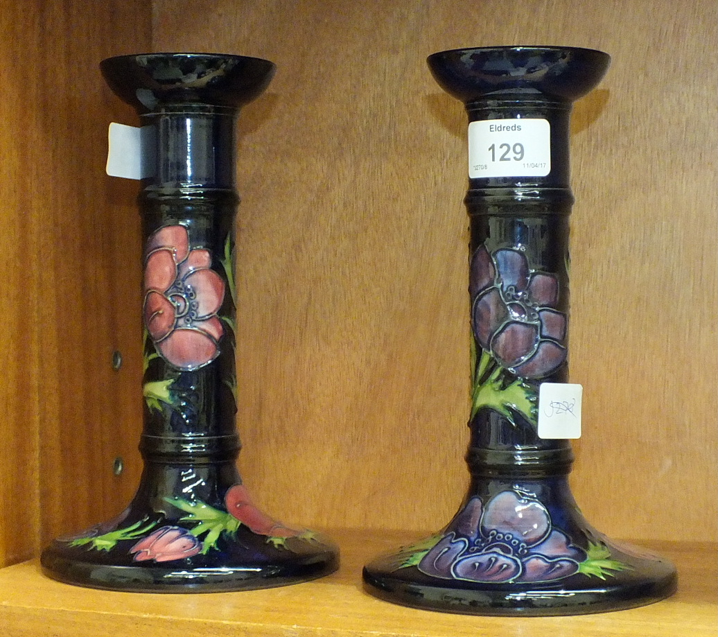 A pair of late-20th century Moorcroft Pottery candlesticks decorated with anemones on a dark blue