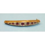 A Victorian curved gold brooch of tapered form alternately set seven round cut rubies and eight