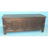 A large antique oak panelled coffer, the fielded panels within reeded stiles extended to form