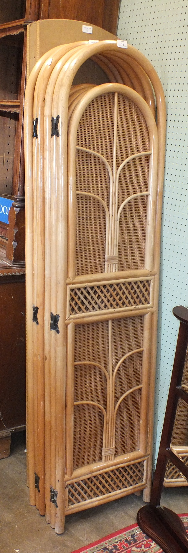 Two modern rattan-framed three-fold draught screens, one other and a modern mirror.