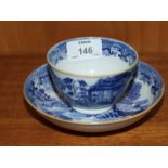 A 19th century English blue and white tea bowl and saucer decorated with buildings.