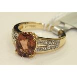 A 9k gold ring set a pink tourmaline between diamond set shoulders, size J, 3g, with certificate