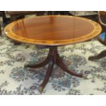 A reproduction mahogany circular dining table with inlaid and cross-banded decoration, on single