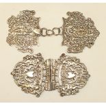 A white metal buckle with pierced decoration, and one other, (2).