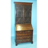 A Georgian bureau/bookcase, the dentil cornice above a pair of astragal-glazed doors, the fall front