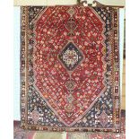 A Persian Qashqai rug with long and central symmetric design on red and blue ground, 156 x 250cm.