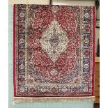 A modern Kashmir rug with central ivory medallion on red ground, 115 x 82cm.
