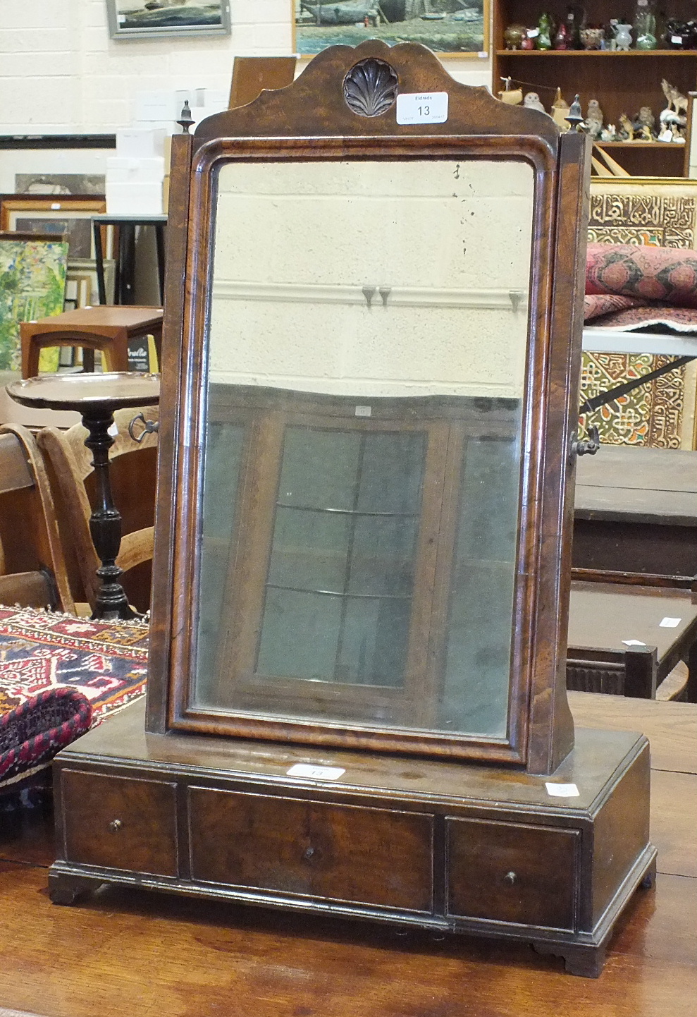 A Queen-Anne-style walnut dressing glass, the rectangular base fitted with three drawers, on bracket