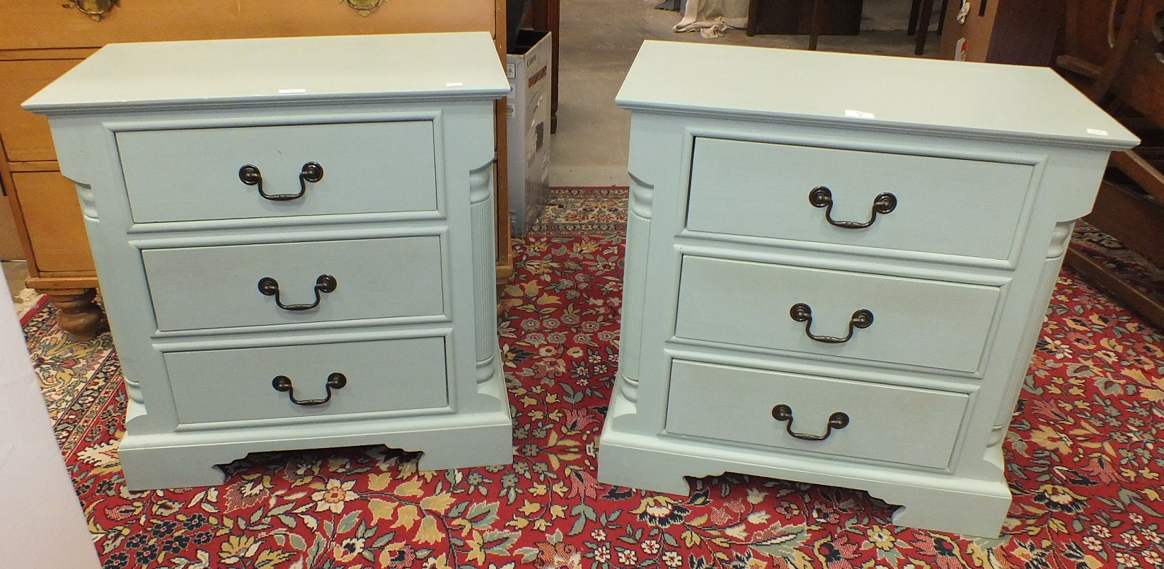 A pair of painted low three-drawer bedside chests on plinth bases, 70cm wide, 68cm high, 40.5cm