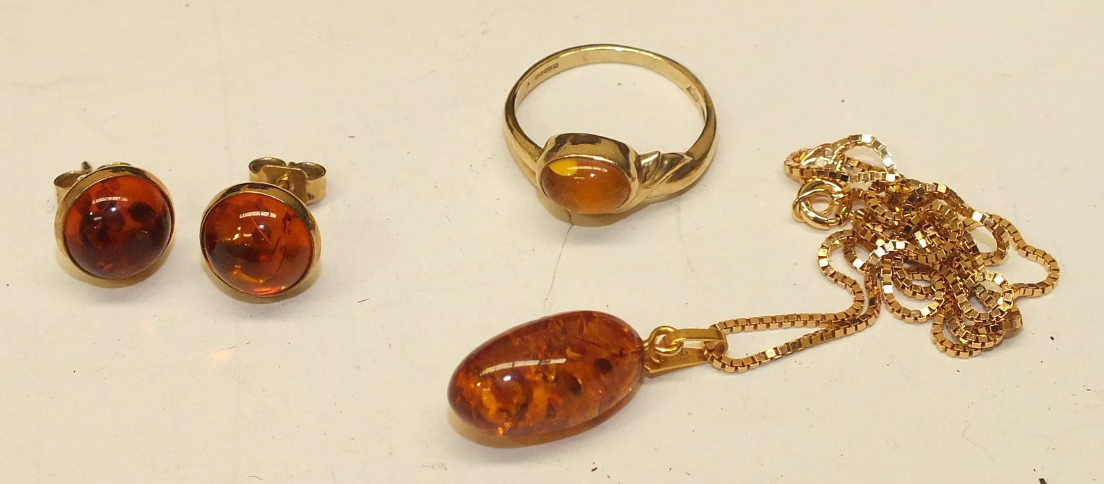 A small 9ct gold ring set amber, size L, an amber pendant on box link chain and a pair of 9ct gold