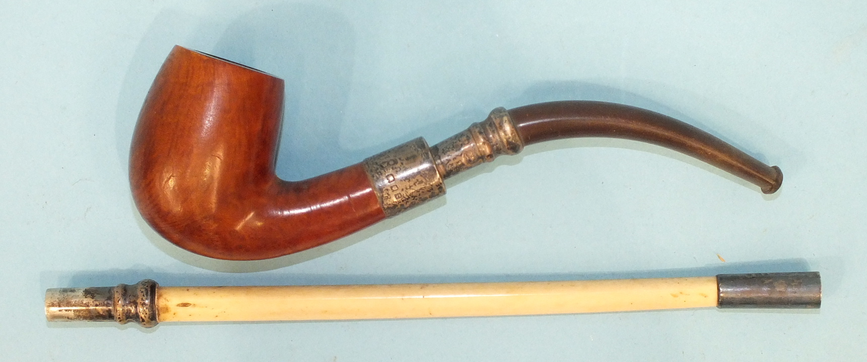 A silver-mounted briar root pipe with detachable mouthpiece and extension.