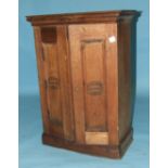 A two-door hardwood small cupboard, the pair of panelled doors with incised oval trade mark Manuel