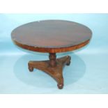 An early-19th century circular mahogany and rosewood-banded breakfast table raised on turned