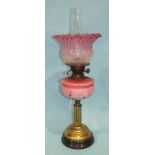 A Victorian oil lamp with etched pink glass shade and moulded pink glass reservoir, on lacquered