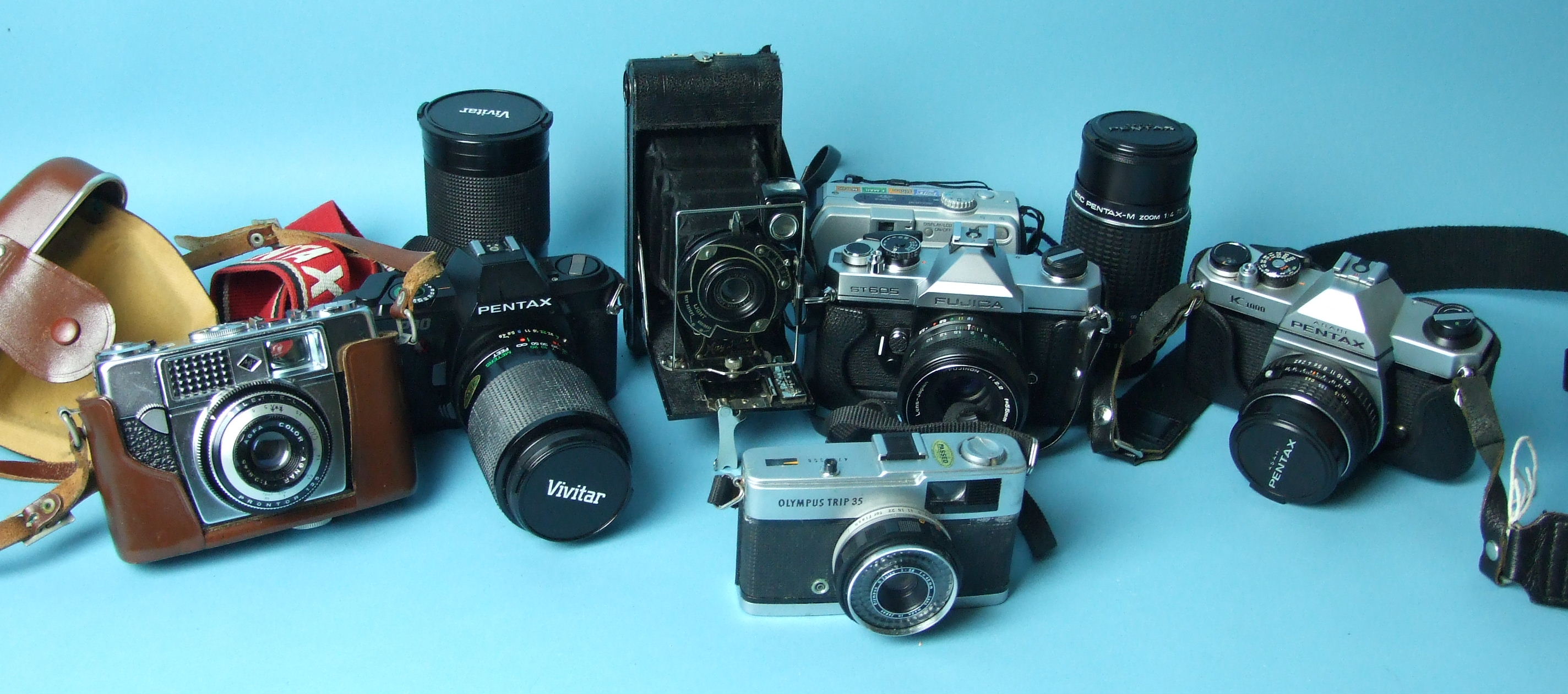 A collection of cameras and lenses, including Pentax P30 PentaxAsahi K1000 and Fujica ST605 cameras,